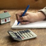 calculatrice-et-maison-sur-table-en-bois
