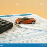 calculatrice-et-voiture-miniature-sur-table-claire