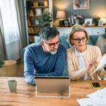 couple-discutant-documents-fiscaux-a-table-lumineuse