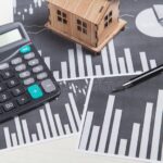 Comment la Plus-Value Immobilière Est-Elle Imposée en SCI maison-et-calculatrice-avec-graphiques-financiers