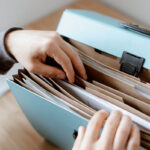 Quelles démarches administratives réaliser avant un déménagement personne-preparant-documents-pour-demenagement-organise