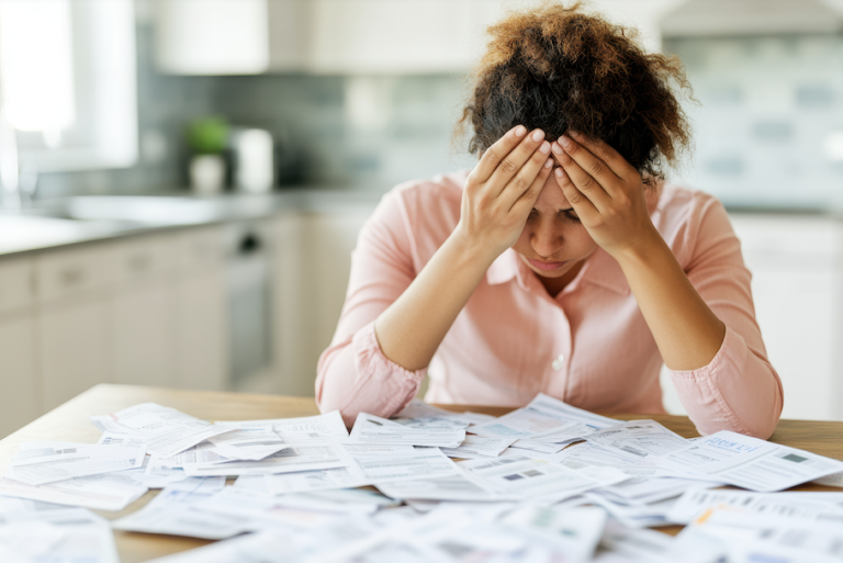 personne reflechissant avec documents financiers eparpilles