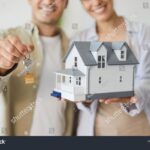personne-souriante-avec-cles-de-maison-et-document-bancaires